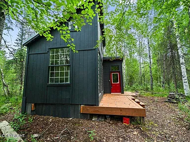Alaska Woodland Cabin for $95,000 on 0.55 Acres With Floor-to-Ceiling Windows, Two Loft Spaces and a Wood Stove